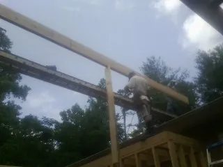 Carpenter setting a ridge beam over a new addition frame — Ice Dam Removal by Roofing Brothers in Murfreesboro