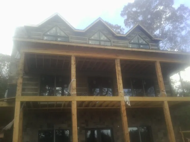 Dormers and porch framing on a large log home under construction — Roof Coating work by our crew in Murfreesboro